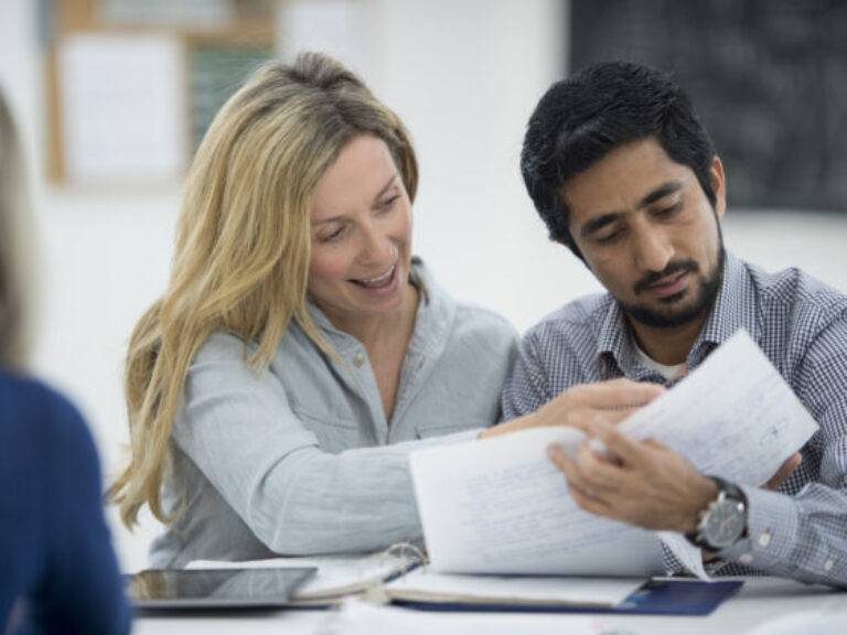 A multi-ethnic group of adult are going back to university and are working on homework and studying together after class.